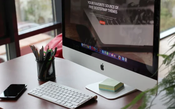 A clean, organized desk setup featuring a computer display, keyboard, and office supplies.
