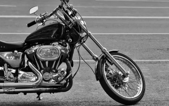 A detailed black and white photo of a chrome motorcycle parked on the road.