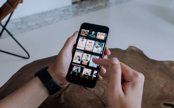 A person using a iphone to explore and select shows on a streaming platform indoors
